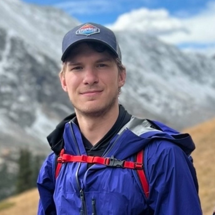 Councilmember Hagenow in hiking gear in front of a mountain.